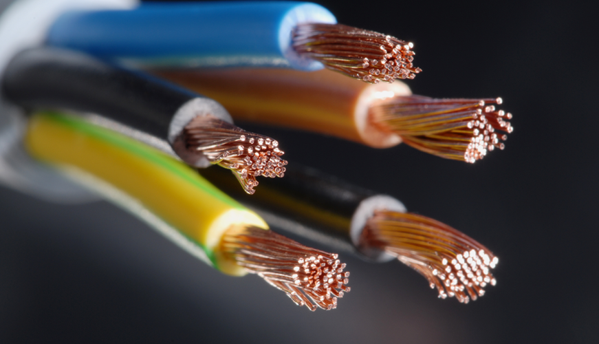 Close-up of the ends of several exposed copper wires in colored insulation, including blue, yellow with green stripes, black, and brown, against a dark background. The wire strands are neatly bundled and visible.